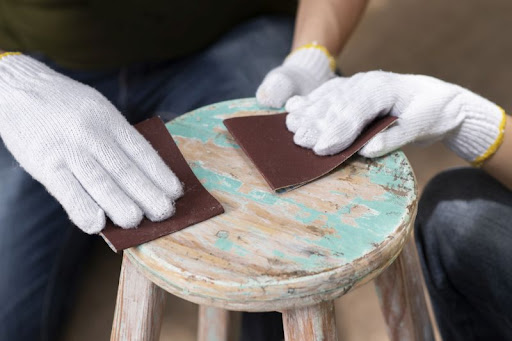 odstraňovanie starej farby z nábytku brúsnym papierom