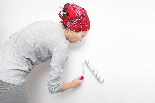 žena aplikuje valčekom na stenu penetračný náter